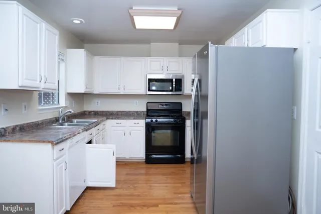 a kitchen with a refrigerator sink and stove top oven