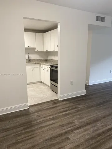 a kitchen with wooden floors and white appliances