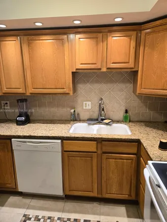 a kitchen with a sink cabinets and a window