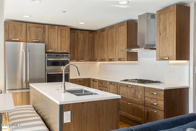 a kitchen with a sink a refrigerator and cabinets