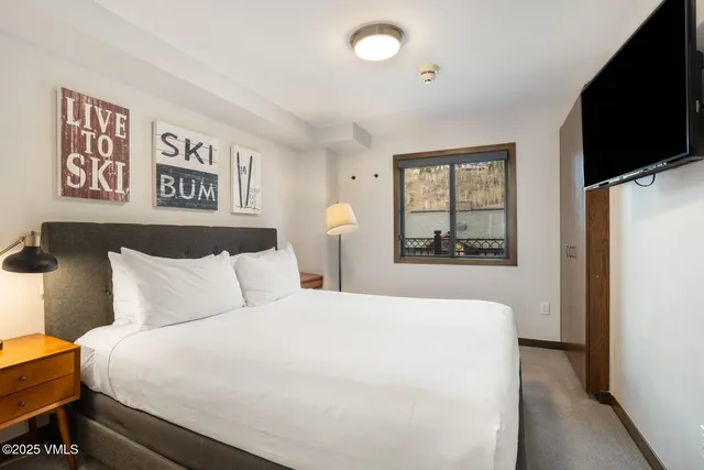 a bedroom with a large bed and a tv