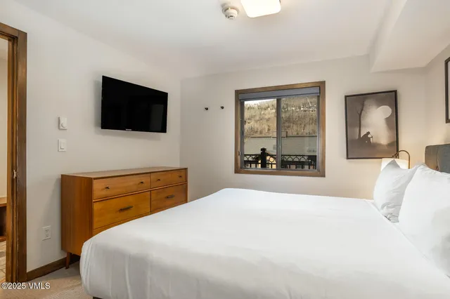 a bedroom with a large bed and a flat screen tv