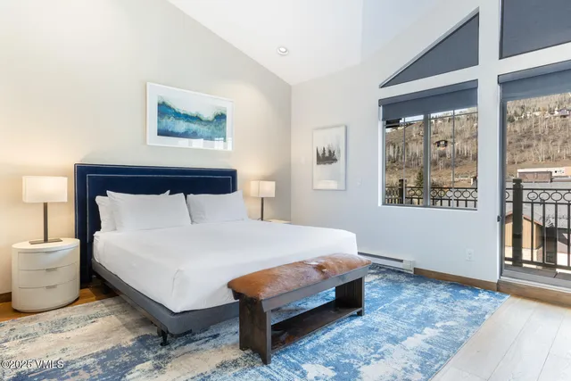 a large bed sitting in a bedroom next to a window