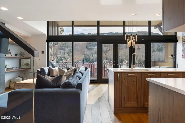 a living room with furniture a large window with kitchen view