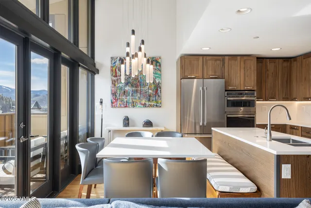 a kitchen with stainless steel appliances granite countertop a refrigerator a sink a stove and a refrigerator