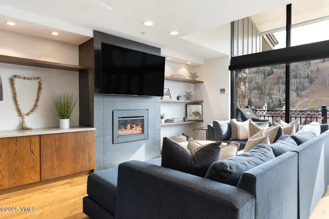 a living room with furniture a flat screen tv and a fireplace