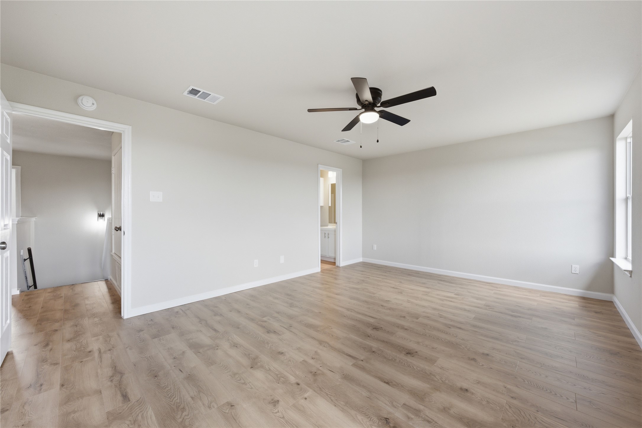 6917 Panda Royle Drive Del Valle, TX 78617 - Photo 12 of 23 A spacious room presents light wood flooring and a refreshing ceiling fan.