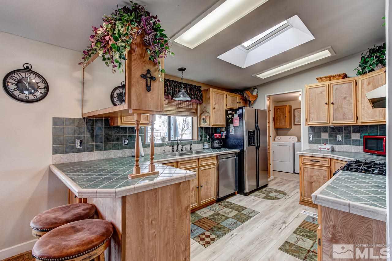 2170 Soda Lake Road Fallon, NV 89406 - Photo 11 of 25 a kitchen with stainless steel appliances granite countertop a stove a refrigerator a oven a sink with a dining table and chairs