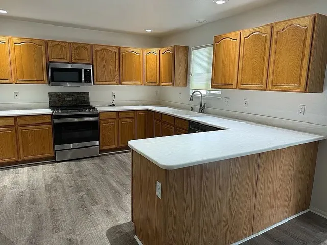 a kitchen with a sink a stove and cabinets