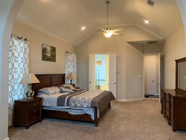 a bedroom with a bed chandelier and a window