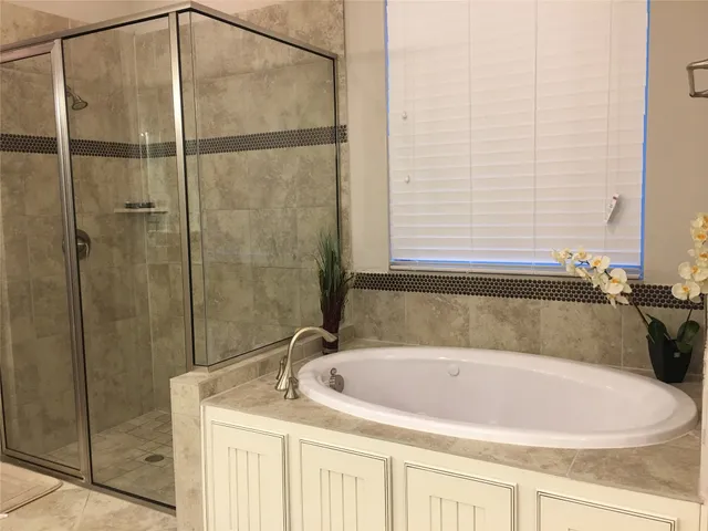 a bathroom with a granite countertop tub and a sink