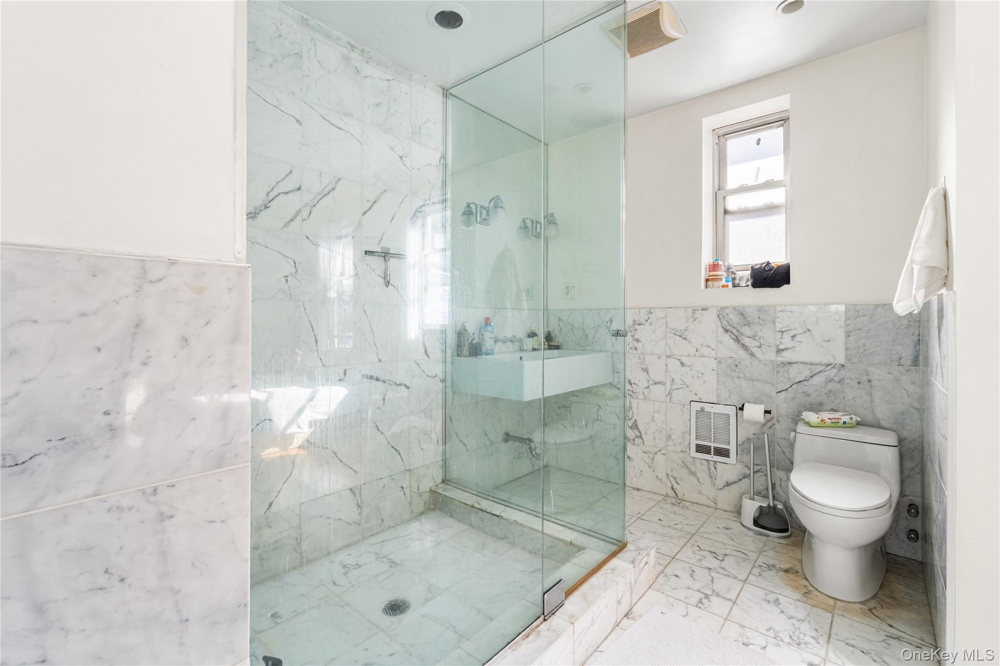 2969 Perry Avenue Bronx, NY 10458 - Photo 14 of 36 a bathroom with a granite countertop shower a mirror and a toilet