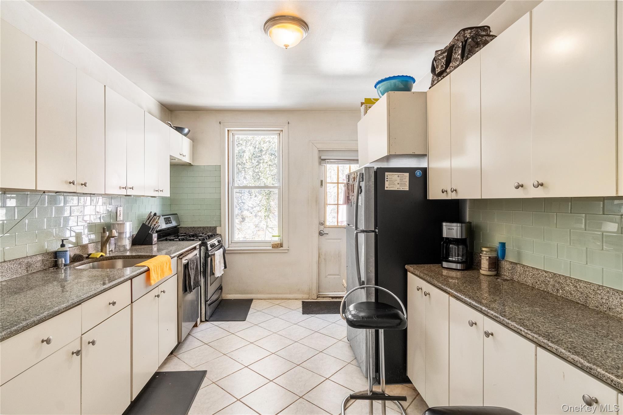 2969 Perry Avenue Bronx, NY 10458 - Photo 20 of 36 a kitchen with a sink a refrigerator and cabinets