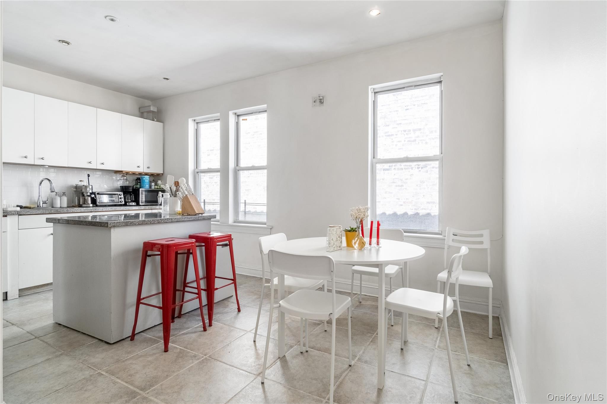 2969 Perry Avenue Bronx, NY 10458 - Photo 7 of 36 a dining room with kitchen island granite countertop furniture a sink a window and stainless steel appliances