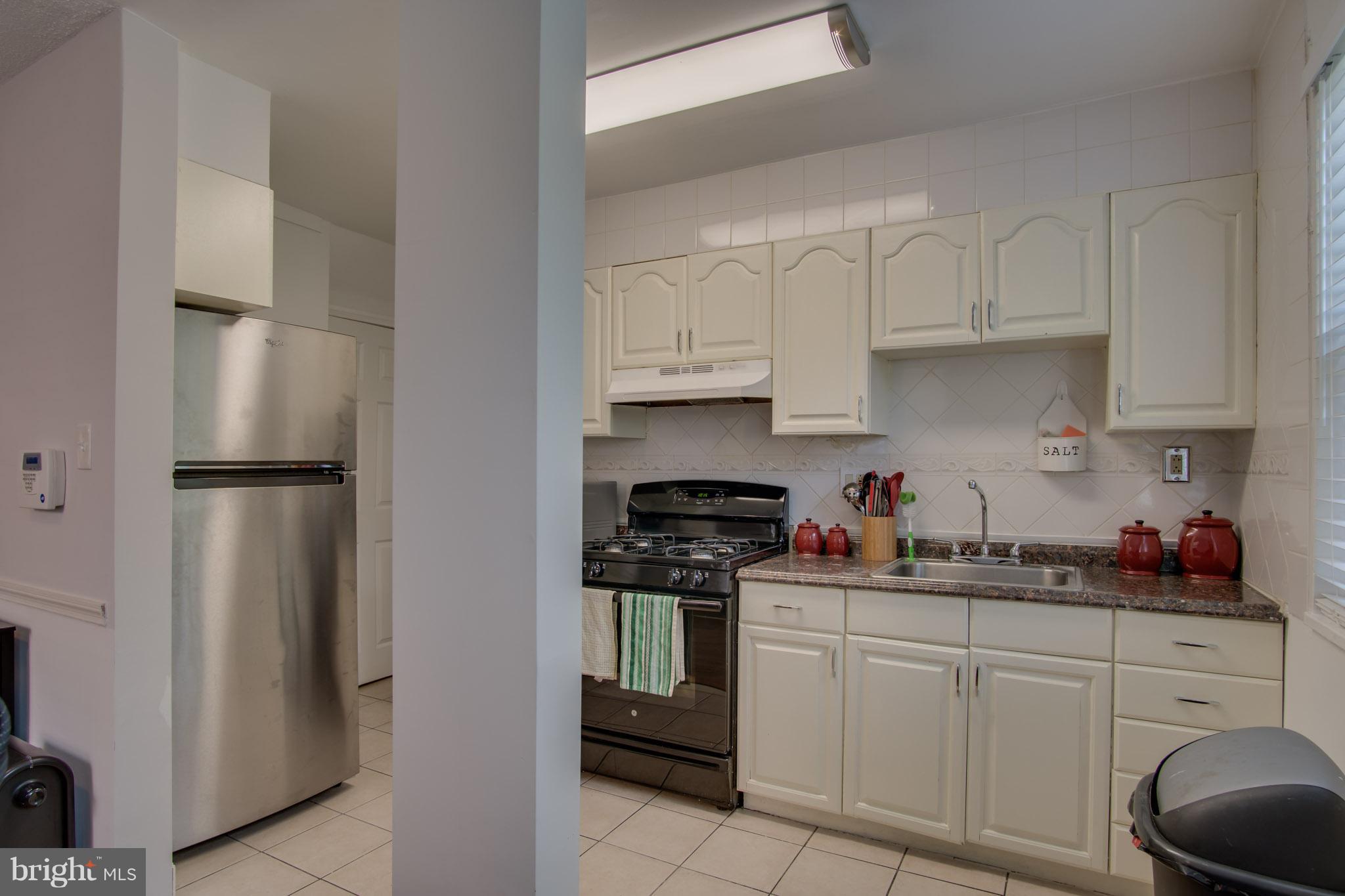 643 Brandywine Street Southeast Washington, DC 20032 - Photo 14 of 26 a kitchen with white cabinets and stainless steel appliances
