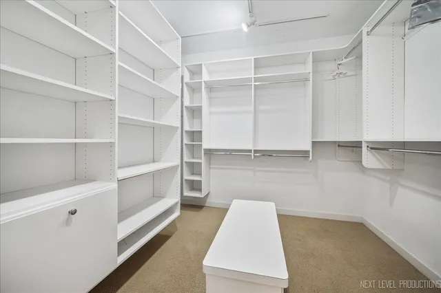 a view of walk in closet with empty racks