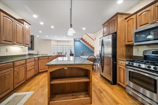 a kitchen with stainless steel appliances granite countertop a sink a stove and a refrigerator