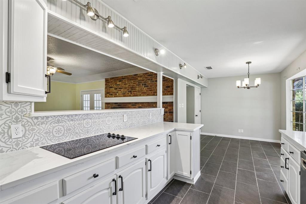 1600 South Timber Court Benbrook, TX 76126 - Photo 11 of 30 Contemporary kitchen with white cabinetry, a built-in cooktop, and a patterned tile backsplash