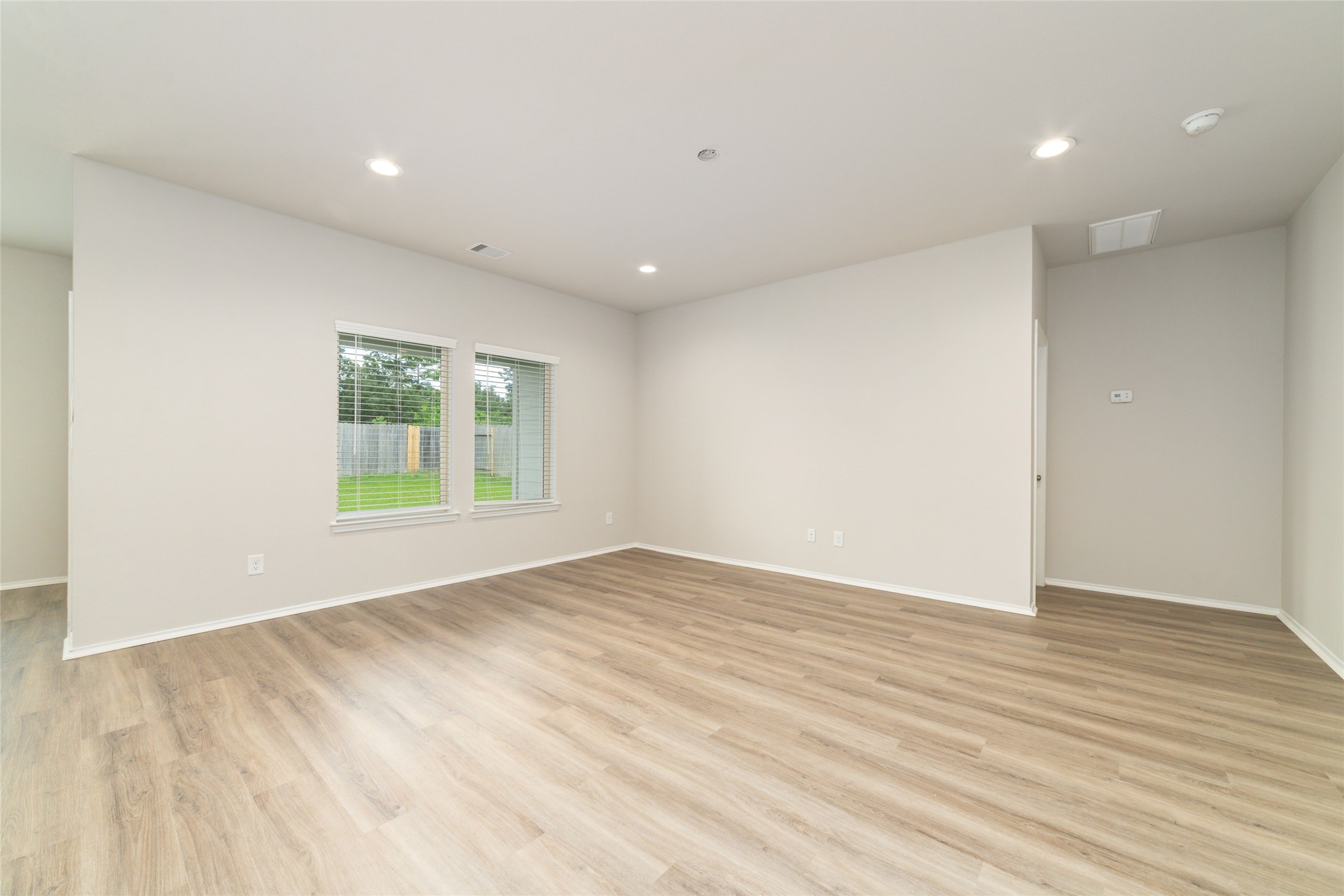 23702 Harrow Field Ln Spring Spring, TX 77373 - Photo 7 of 32 an empty room with wooden floor and windows