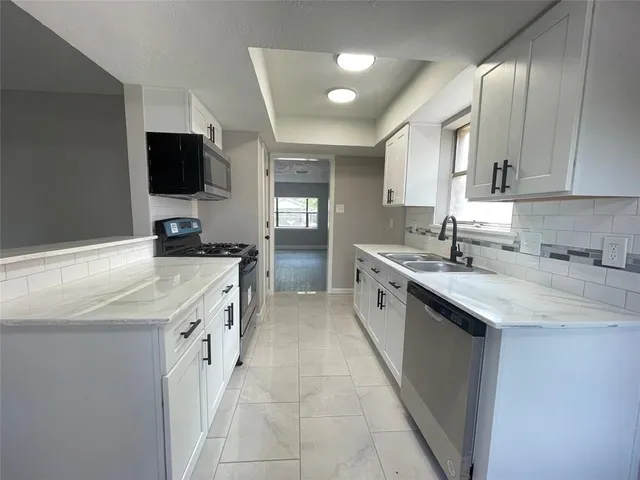a kitchen with a sink stove and cabinets