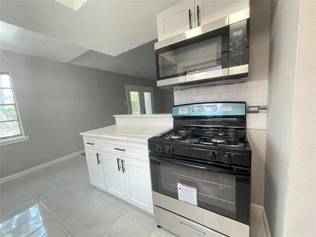 a stove top oven sitting inside of a kitchen
