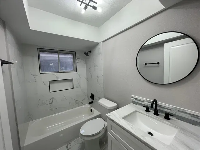 a bathroom with a sink mirror bathtub and toilet