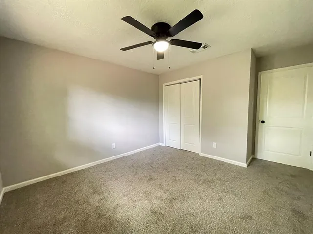 an empty room with closet and fan