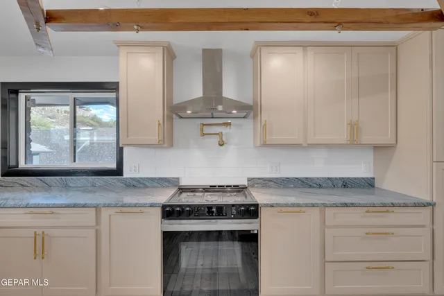 a kitchen with granite countertop white cabinets and a stove