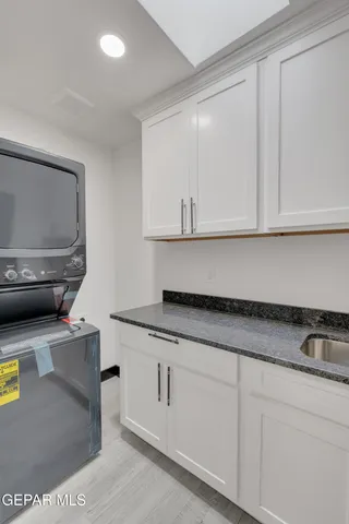 a kitchen with granite countertop white cabinets and sink
