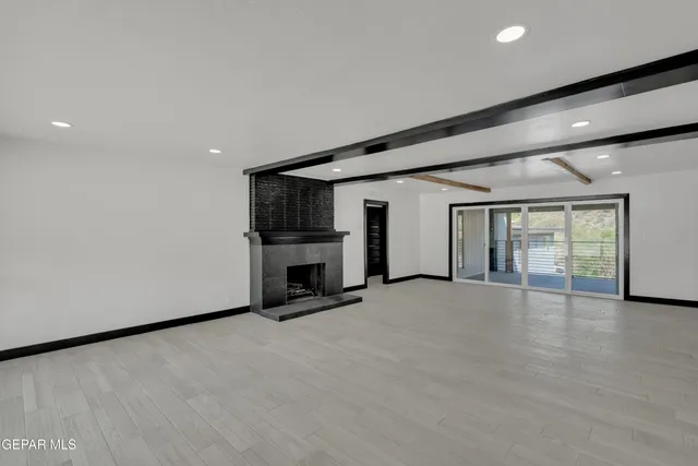 an empty room with fireplace and windows