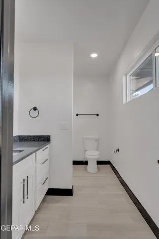 a bathroom with a granite countertop sink and white cabinets