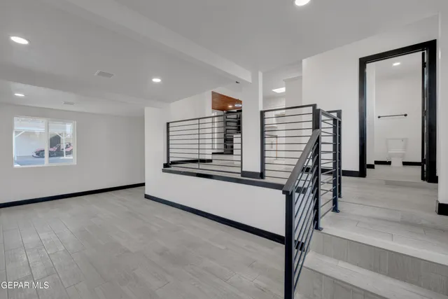 a view of an empty room with stairs and furniture
