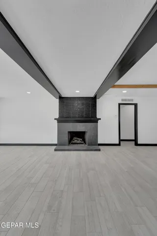 a view of empty room with wooden floor and fireplace