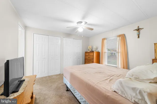 a bedroom with a large bed a flat tv screen and dresser