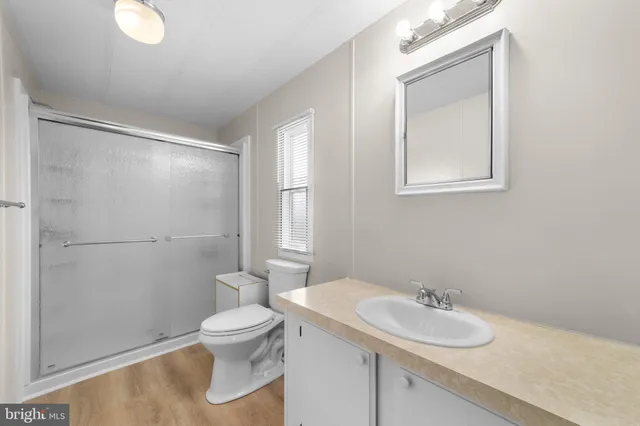 a bathroom with a granite countertop sink toilet and a mirror