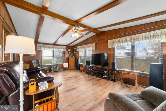 a living room with furniture a flat screen tv and a floor to ceiling window