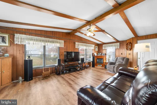 a living room with furniture a flat screen tv and large windows