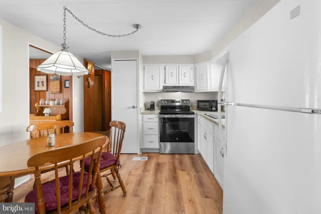 a kitchen with stainless steel appliances a stove a refrigerator and a dining table