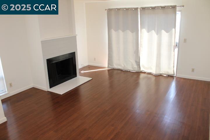 4811 Appian Way, Unit 3/5 El Sobrante, CA 94803 - Photo 2 of 27 a view of a livingroom with wooden floor and a fireplace