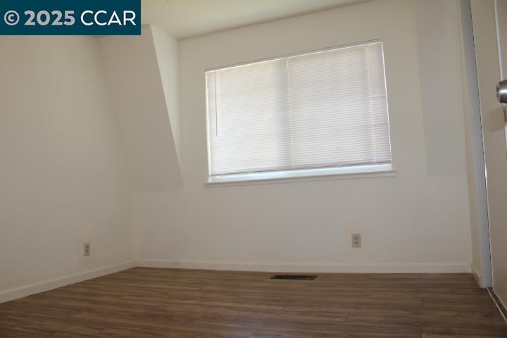 4811 Appian Way, Unit 3/5 El Sobrante, CA 94803 - Photo 21 of 27 a view of an empty room with wooden floor and a window