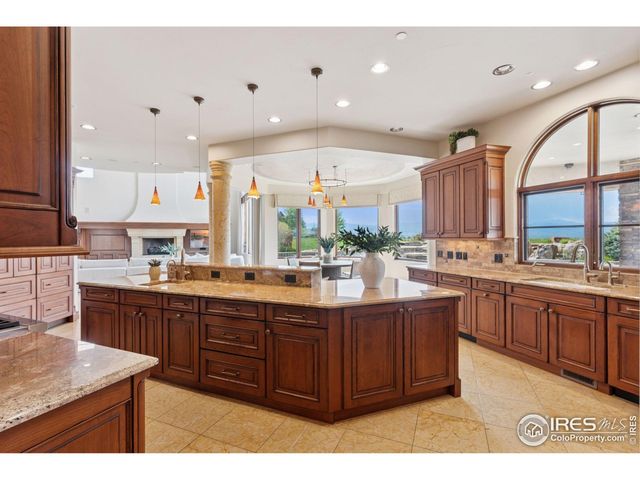 a kitchen with stainless steel appliances kitchen island granite countertop a stove a sink a dining table and chairs