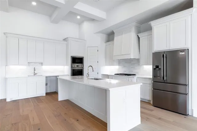 a kitchen with stainless steel appliances a refrigerator sink and cabinets