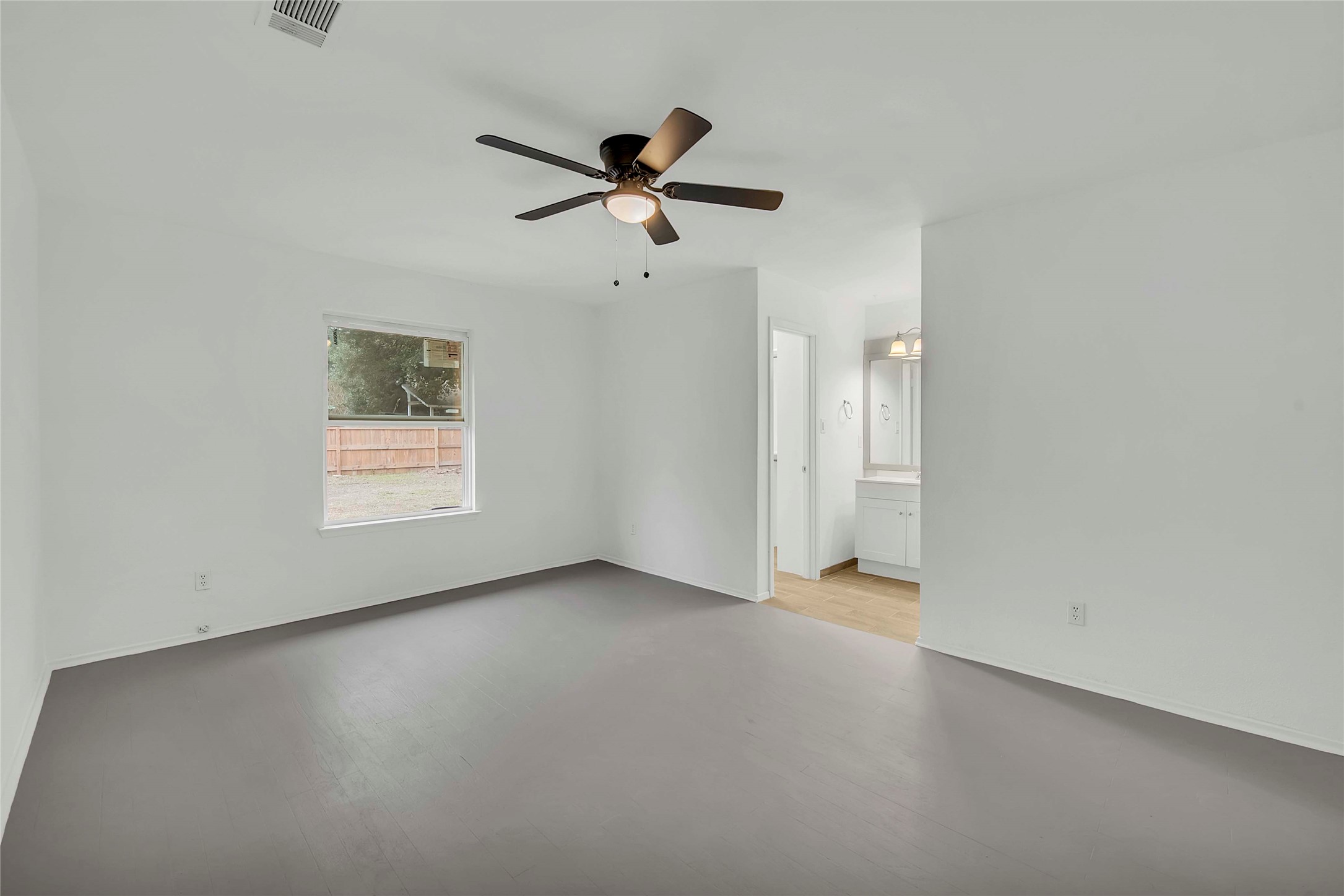7209 Gunnison Pass Austin, TX 78724 - Photo 8 of 19 A well-proportioned primary bedroom offers seamless entry to its private bathroom, featuring a light wood flooring.