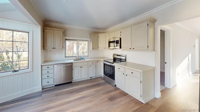 a kitchen with white cabinets sink and window