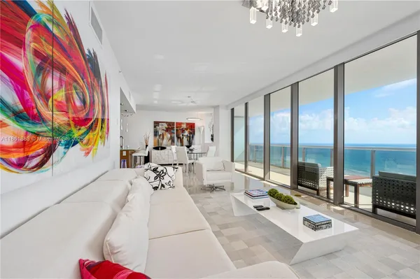 a living room with furniture and a floor to ceiling window