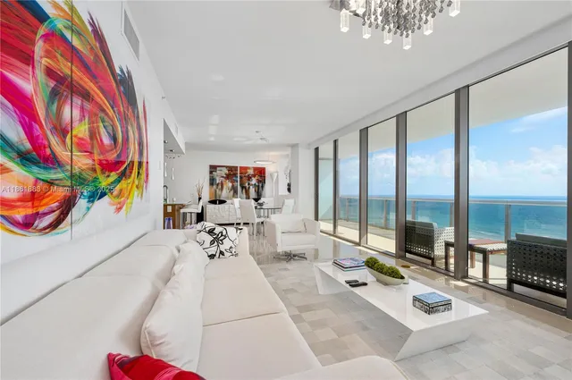 a living room with furniture and a floor to ceiling window