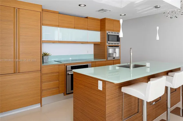 a large kitchen with stainless steel appliances a sink and cabinets