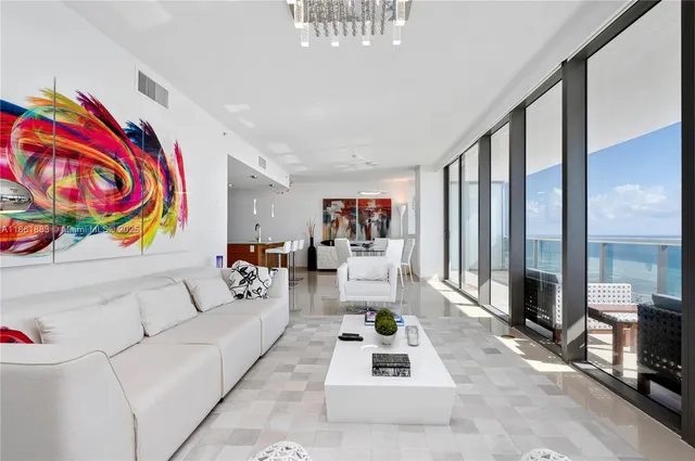 a living room with furniture and a floor to ceiling window