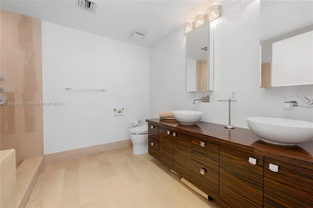 a bathroom with a bathtub shower sink mirror vanity and toilet