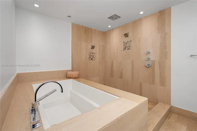 a spacious bathroom with a tub sink and mirror